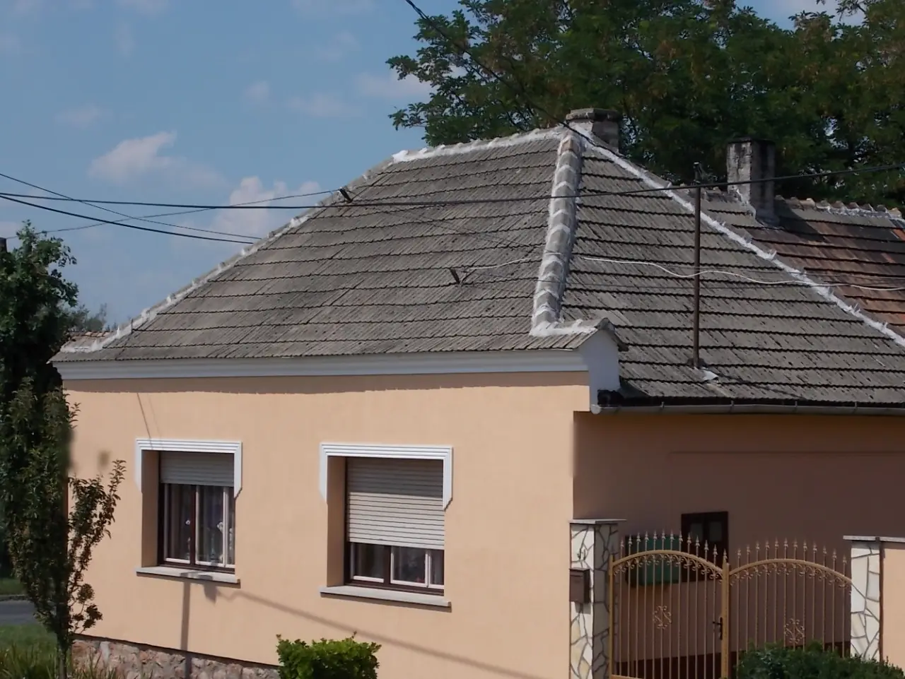 Ungarisches Würfelhaus mit Zeltdach und verputzter Fassade im Sommersonnenschein